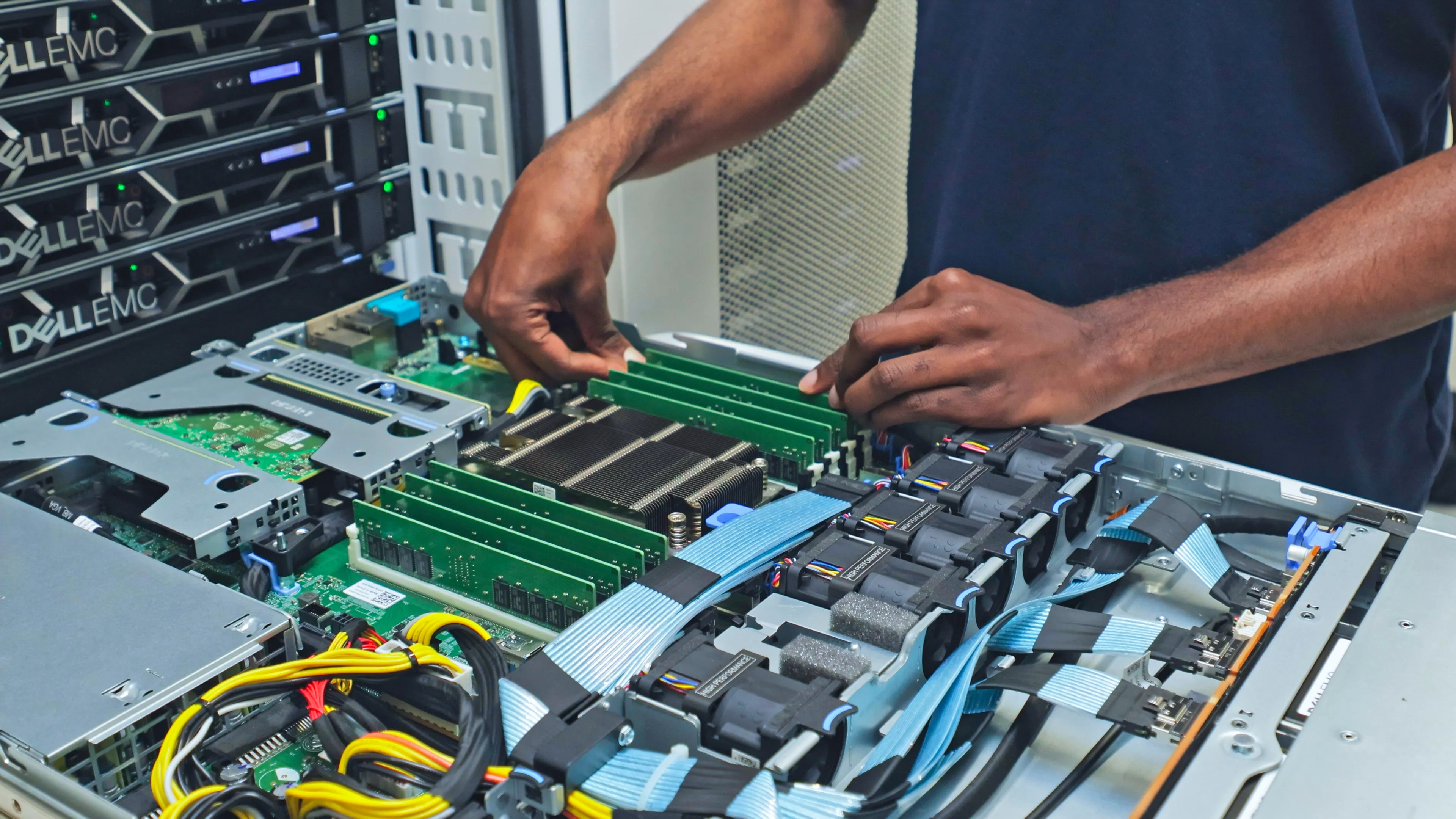 DACPROS engineer installing RAM modules into an open Dell EMC server motherboard during a rack build deployment.